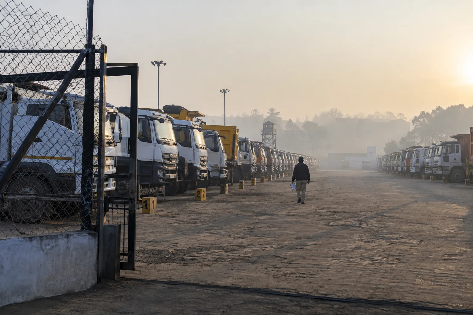 A yard of recovered trucks and machines at dawn